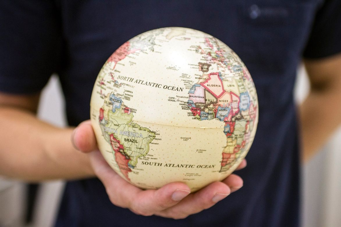 Imagem de uma pessoa segurando um globo terrestre na palma da mo